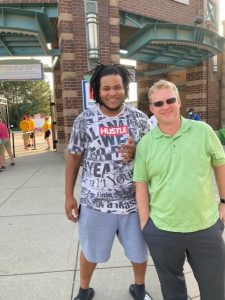 Two men stand outside a baseball stadium